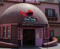 The Brown Derby, originally a hat shop, has been re-themed to Sesame Street. The Elmo marquee was replaced by Bert and Ernie in 2013.