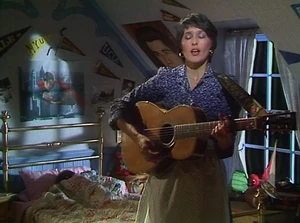 Joan Baez on The Muppet Show, with a Superman poster behind her.