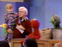A little girl meets Elmo