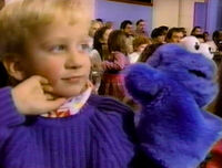 A boy with a Cookie Monster puppet