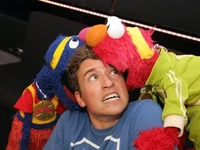Grover and Elmo bite Greg James 2012.jpg (67 KB)