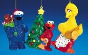 Blow ornaments; Cookie Monster with a Santa hat and bag of gifts, Elmo with a Christmas tree and his toy David, and Big Bird with a saxophone. (2006) SE0042