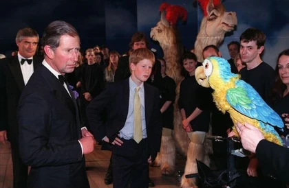Charles, Prince of Wales and his youngest son, Prince Harry, meet Polynasia the parrot at the premier of the West End musical at the Labatt's Apollo in London (July 6, 1998)