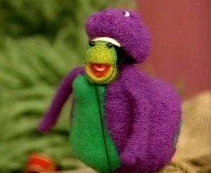 A worm dressed as Barney in Wormy Gras.