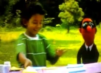 Agen Rahasia 123 gets help from a kid named Adam in a sketch where Agen Rahasia 123 must fix a color and shape pattern banner that the Goat broke apart.