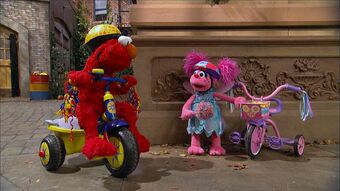 elmo riding a tricycle