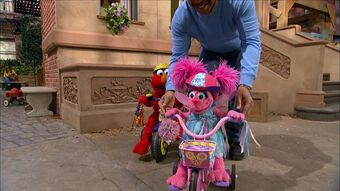 elmo riding a tricycle