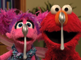 Abby and Elmo hang spoons.