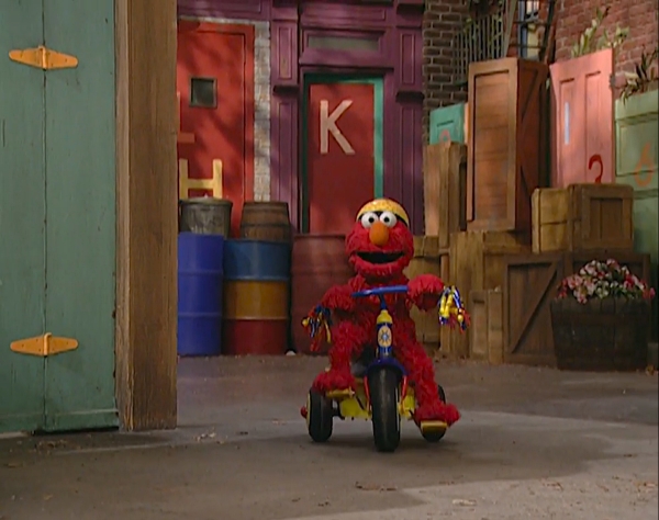 elmo riding a tricycle