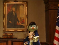 An Elvis as Thomas Jefferson, standing before Washington's portrait.