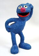 Grover with one hand on his head and one hand on his back