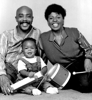 Beaming parents  and  with their adopted son .