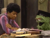 Oscar blowing dust off a book in Sesame Street Episode 2024
