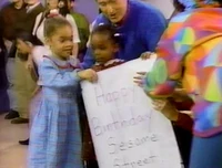 Two little girls present their birthday card to Sesame Street