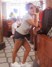 Marian Renta standing in a restaurant with sunshades on during the shooting of the music video for "Leave You".