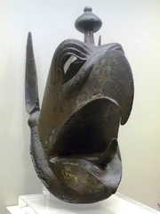 A bronze head of a Griffin, 27.8 cm (10.9 in) in height, that  was a protome (decorative adornment) from a 7th century BCE cauldron discovered in Olympia, Greece.