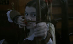 Lucy aiming at the  with Susan's bow and arrow.