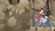 Sarada and Mitsuki stop the rocks from falling on the people.