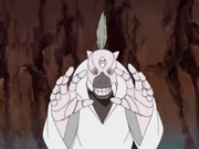 Puppet 2: This puppet had grey markings around its mouth area and hair coming from a single point on its head. It was shown to have colossal fists and fierce taijutsu skills. In the anime it was able to extend its arms to form a sort of cage to trap opponents, where it would then launch four small bombs from its mouth. Since the explosion was accurate and very small, it dealt a great amount of damage to enemies whilst not damaging the cage.