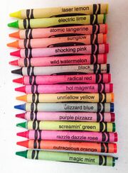 Laser Lemon crayon with other fluorescent crayons and a black one.