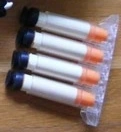 Glow-In-The-Dark Mega Darts loaded into a four dart clip. Note how the bottom of the dart's body reveals a regular-colored Mega Dart; the white, glow-in-the-dark part is just phosphorescent paper wrapped around the dart.