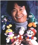 Miyamoto with various Mario plush toys.