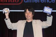 Miyamoto holding a GameCube and Wavebird.