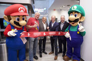 Mascots of Mario and Luigi with their long time voice actor Charles Martinet at the ribbon-cutting ceremony for Nintendo NY