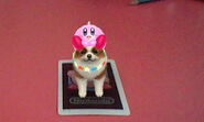 A dog standing on the 'Kirby' card and wearing a kirby hat.