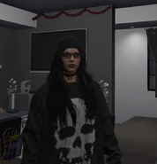 Closeup of Cassie umasked, wearing her signature sunglasses and a skull sweater.