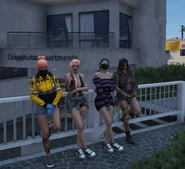 Finn (dressed as V), V, Benny, and Charlotte outside apartments