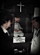 A photo of Annabelle in her display case (with Ed and Lorraine Warren)