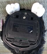 The base of a Witch's Cat Furby with white eyelashes and white eyelids that has a marking saying 'C015A' on its base