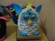 A Rain Cloud Furby with various other Furbies in the background.