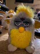 A Banana Peel Furby with green eyes