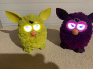 A Sprite Furby with a Plum Fairy Furby.