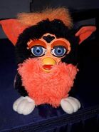 A Tart Tangerine Furby with blue eyes