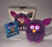 A Voodoo Furby with its box and manual