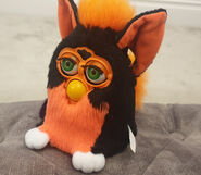 A Tart Tangerine Furby with neon green eyes