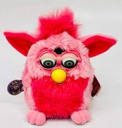 A Pink Flamingo Furby with green eyes