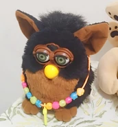 A Gorilla Furby with the necklace of a Galaxy Hey Furby