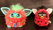Coral Hey Furby next to a Ladybug Furby