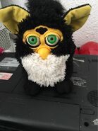 A Penguin Furby with neon green eyes