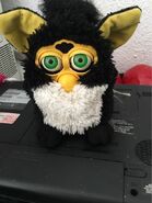 A Penguin Furby with neon green eyes