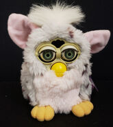 Sun bleached Leopard Furby (its hair has turned white, it’s faceplate is yellow, and it’s black spots have turned brown)