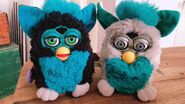 Blueberry Furby next to a Green Bean Furby