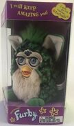 A Turtle Furby with gray eyes in its box