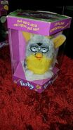 A Banana Peel Furby in a German box