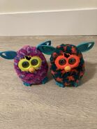 An Orange Stars Furby Boom with a Purple Waves Furby Boom.