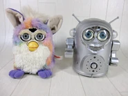 A Japanese Tie Dye Furby next to a silver Space Robby
